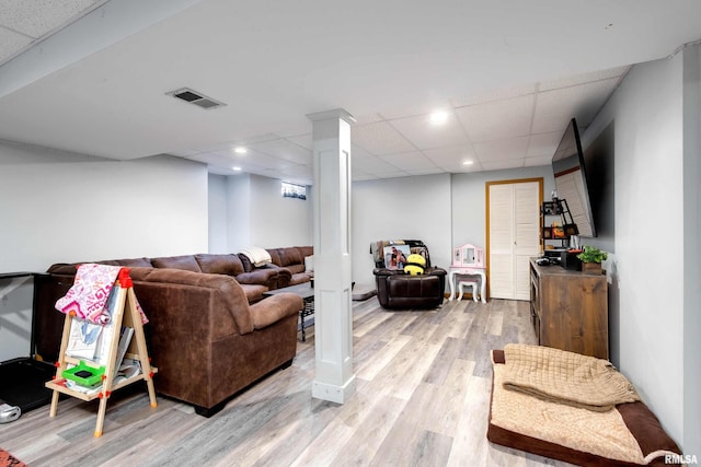 living room featuring a paneled ceiling and light hardwood / wood-style flooring