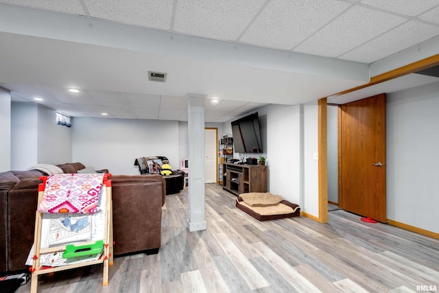 living room featuring a drop ceiling and light wood-type flooring