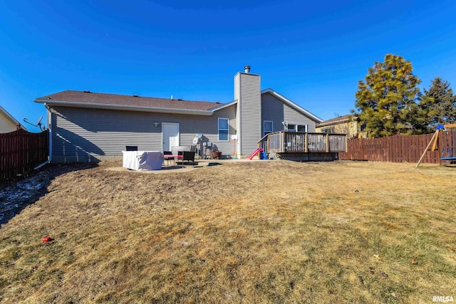 back of house featuring a yard, a deck, a patio area, and a playground