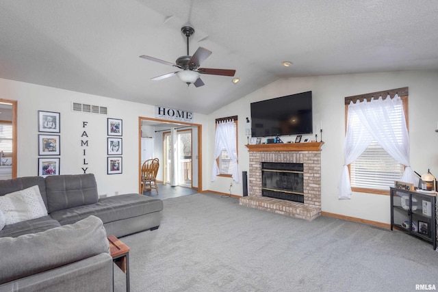 living room with lofted ceiling, a brick fireplace, a textured ceiling, carpet flooring, and ceiling fan