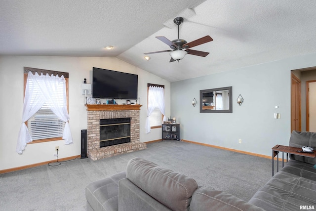 carpeted living room featuring ceiling fan, lofted ceiling, a brick fireplace, and a textured ceiling