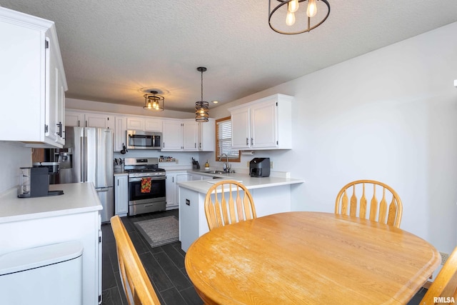 kitchen with white cabinetry, sink, stainless steel appliances, and a textured ceiling