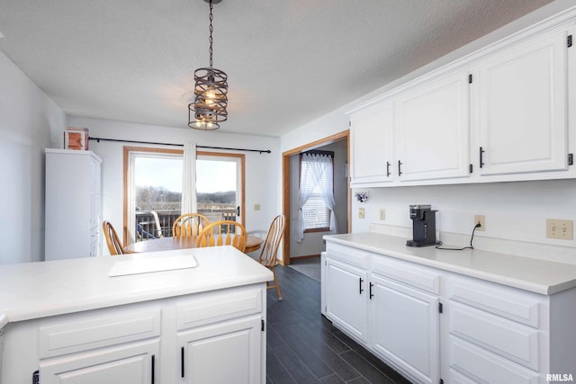 kitchen featuring white cabinetry, a textured ceiling, and decorative light fixtures