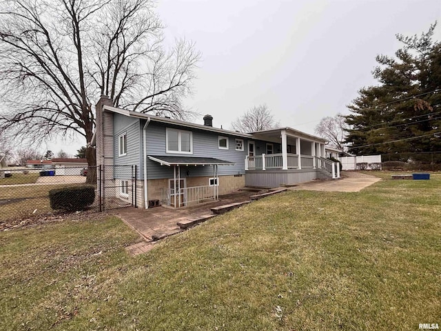 rear view of house featuring a patio area and a lawn