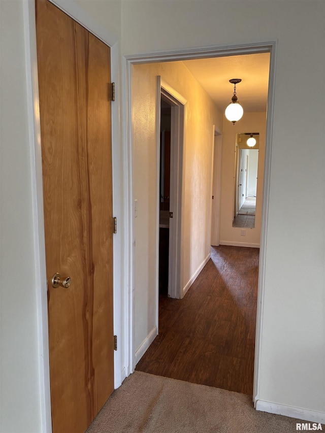 hall with dark colored carpet