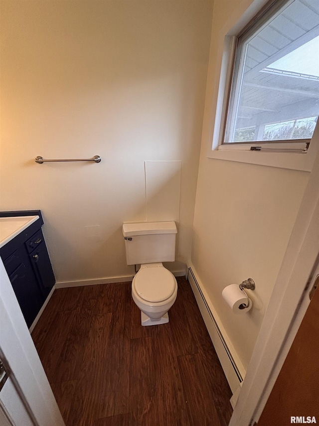 bathroom with baseboard heating, vanity, toilet, and hardwood / wood-style flooring