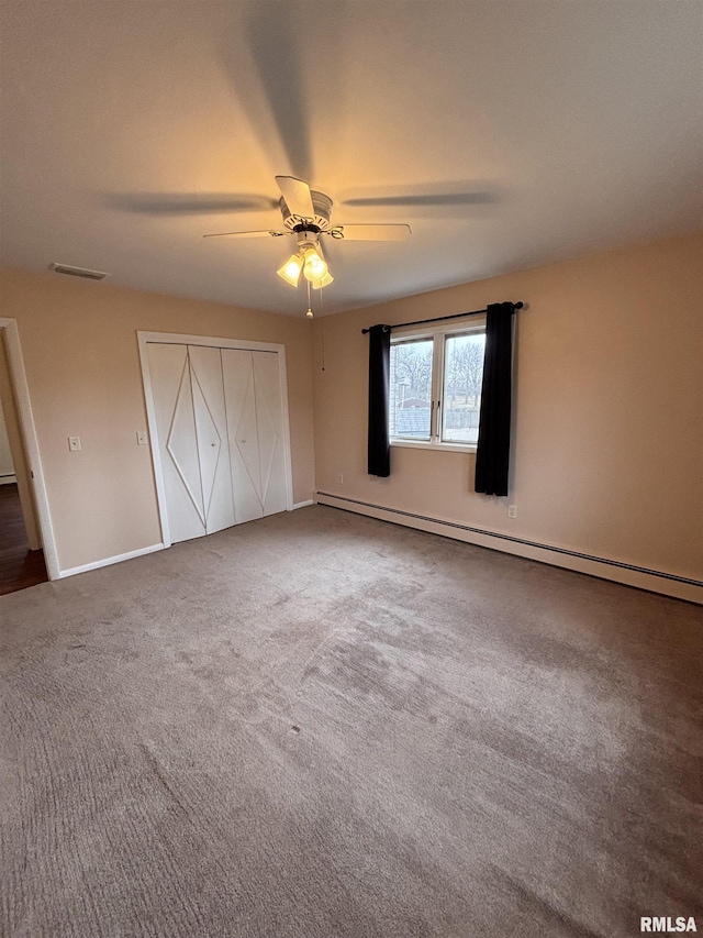 unfurnished bedroom featuring a baseboard heating unit, a closet, ceiling fan, and carpet