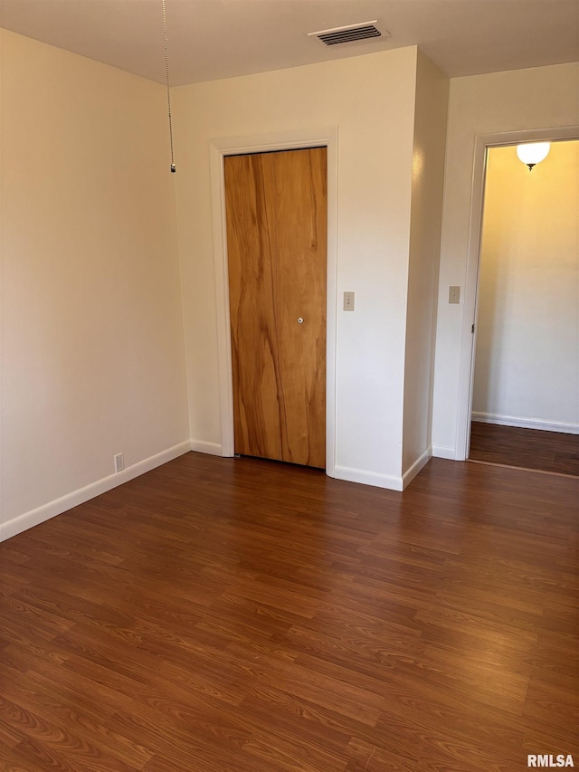 empty room with dark hardwood / wood-style flooring