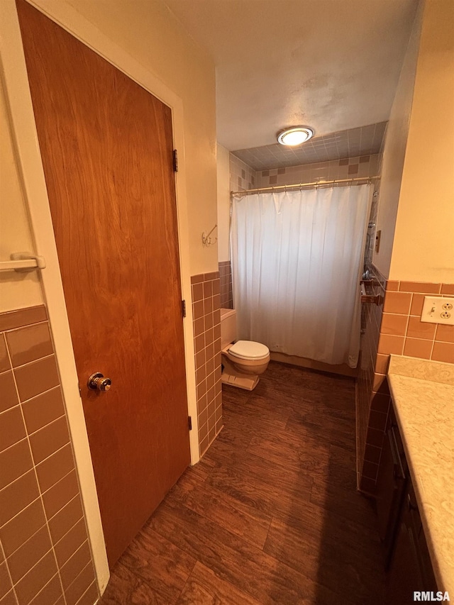 bathroom featuring tile walls, hardwood / wood-style floors, vanity, and toilet