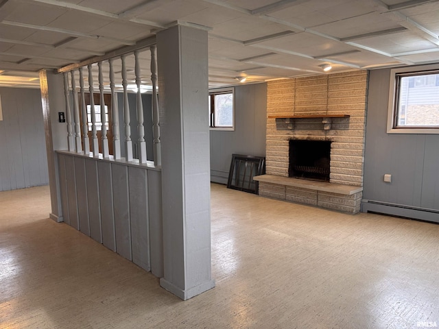 interior space featuring baseboard heating, a fireplace, and wood walls