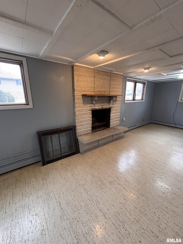 basement featuring a baseboard heating unit, a fireplace, and wooden walls