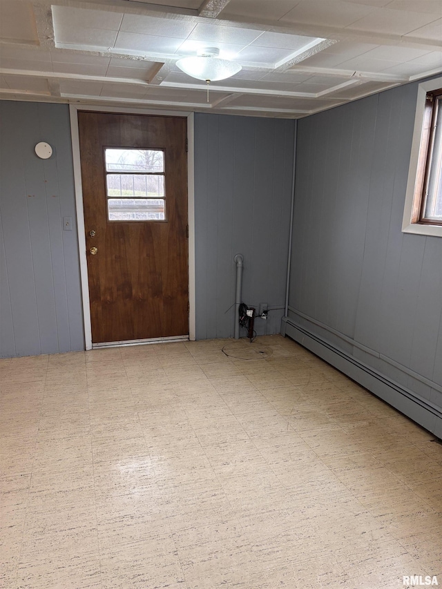 basement with a baseboard radiator and wood walls