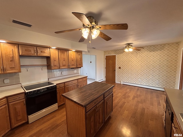 kitchen featuring electric stove, baseboard heating, dark hardwood / wood-style floors, a kitchen island, and decorative backsplash