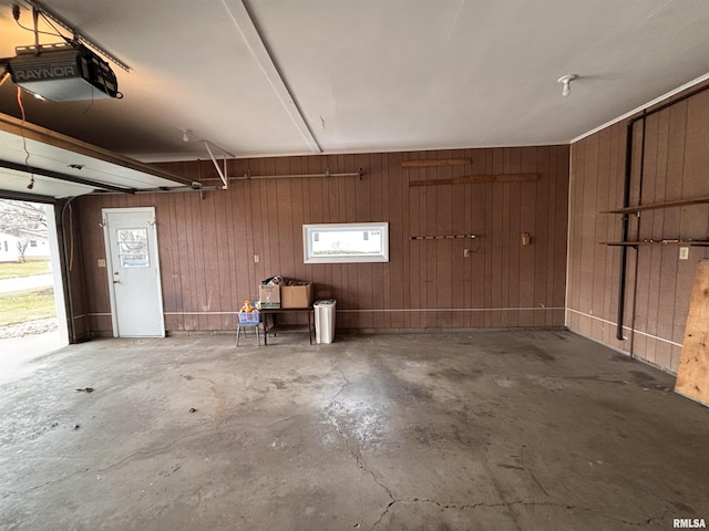 garage featuring a garage door opener and wooden walls