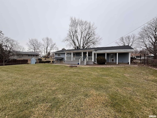 view of front of property featuring a porch, a front yard, and a storage shed