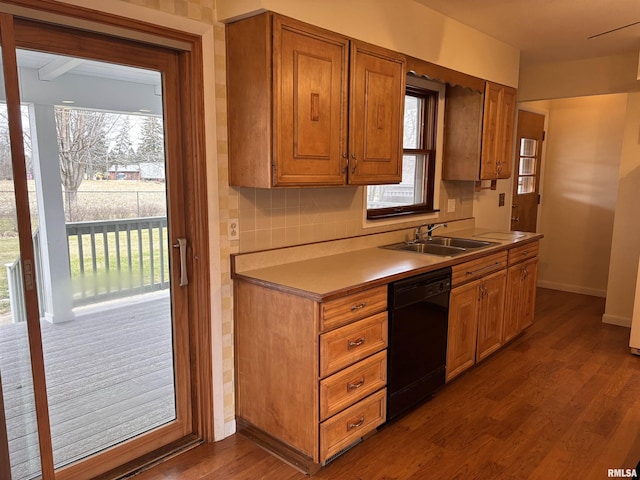 kitchen with dishwasher, sink, hardwood / wood-style floors, and backsplash