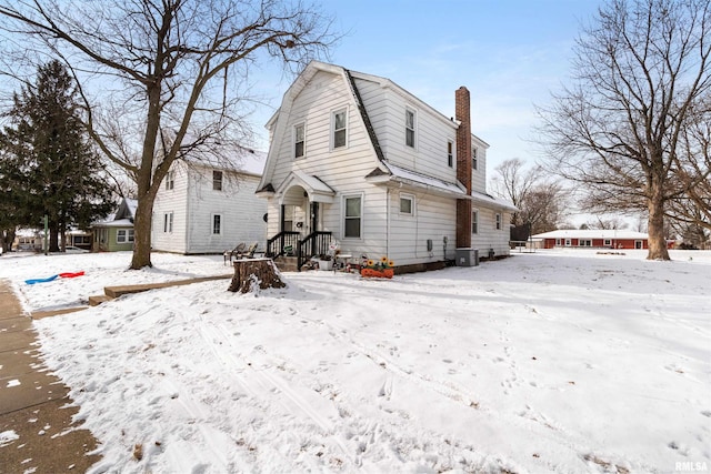 snow covered property with central AC unit