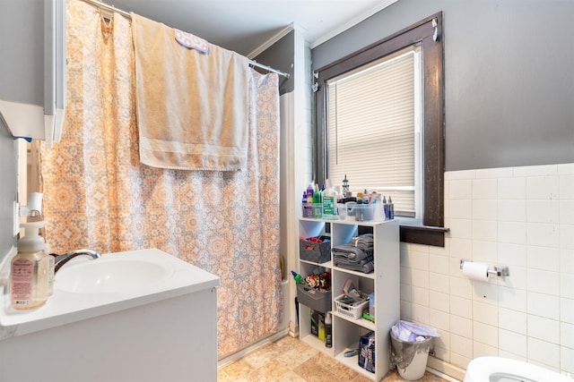 bathroom with walk in shower, toilet, sink, and tile walls