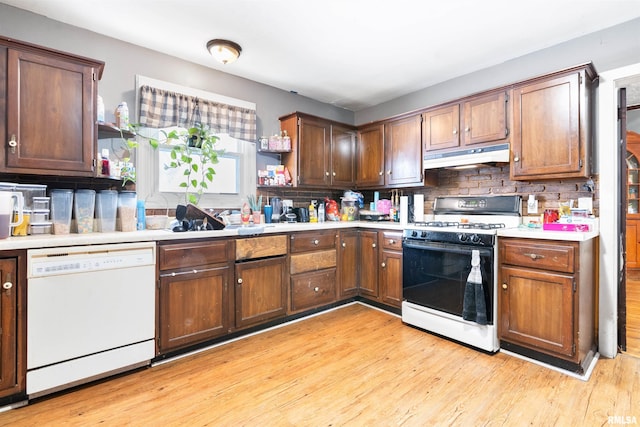 kitchen featuring white appliances, decorative backsplash, and light wood-type flooring