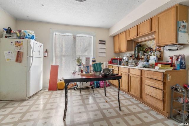 kitchen with white refrigerator and a textured ceiling