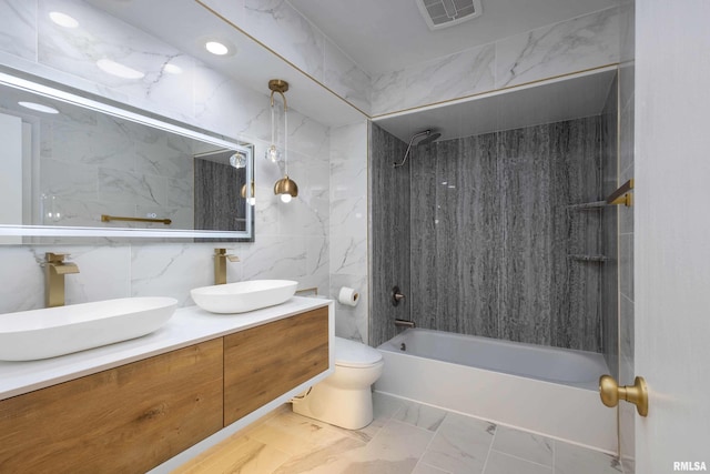 full bathroom featuring washtub / shower combination, vanity, toilet, and tile walls