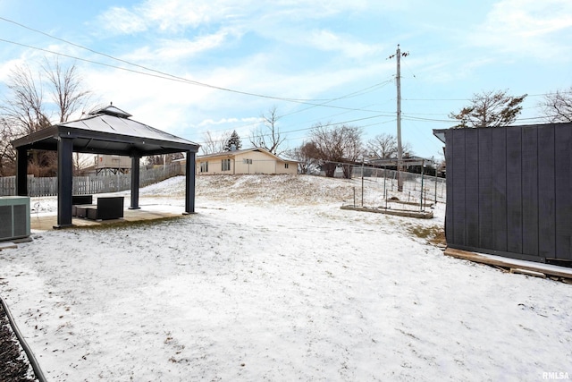 yard layered in snow featuring a gazebo and central AC unit