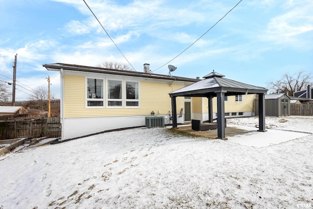 snow covered property featuring a gazebo, a storage shed, and central air condition unit