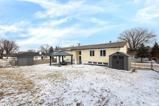 snow covered house with a gazebo and a storage unit