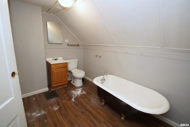 bathroom with lofted ceiling, a bathtub, hardwood / wood-style flooring, vanity, and toilet