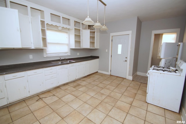 kitchen with pendant lighting, sink, gas range gas stove, and white cabinets