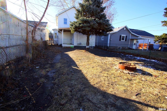 rear view of property with an outdoor fire pit