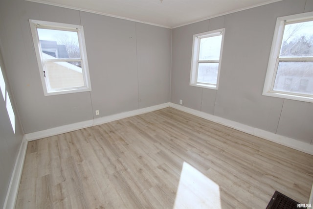 empty room featuring ornamental molding and light hardwood / wood-style floors