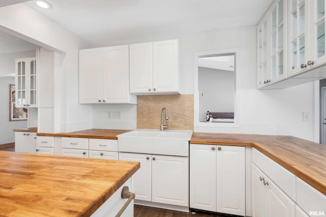 kitchen with wood counters, sink, dark hardwood / wood-style floors, and white cabinets