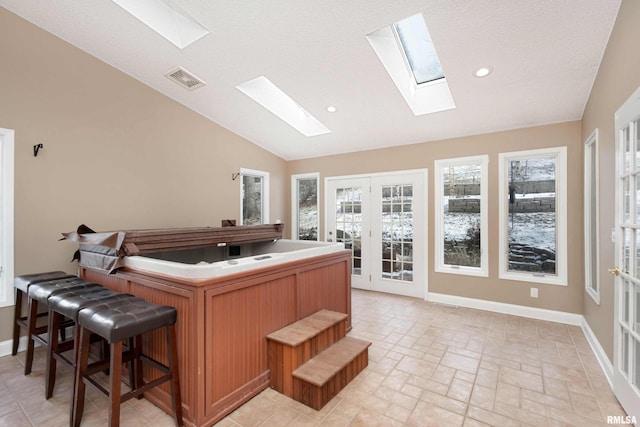 office area with vaulted ceiling with skylight and a textured ceiling