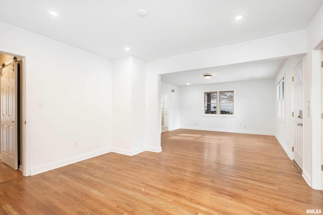 empty room featuring a textured ceiling and light hardwood / wood-style floors