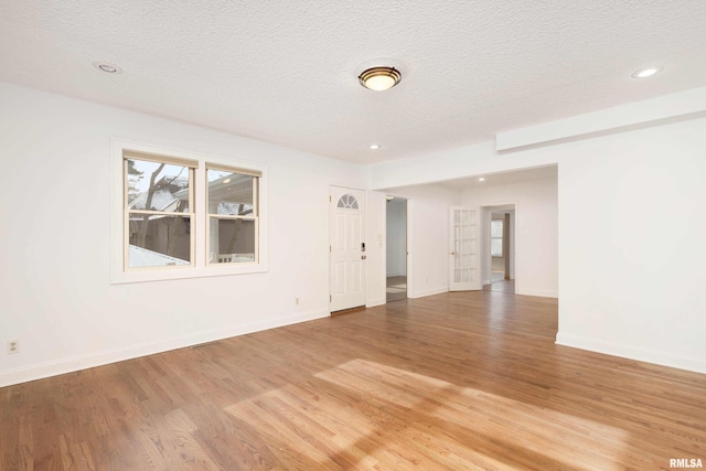 spare room with hardwood / wood-style floors and a textured ceiling