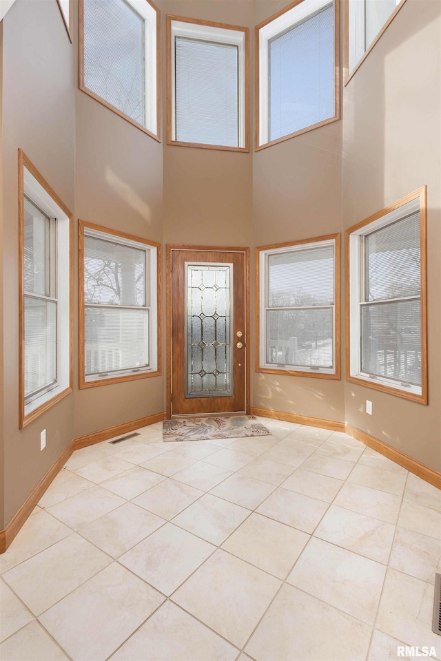 tiled foyer with a towering ceiling