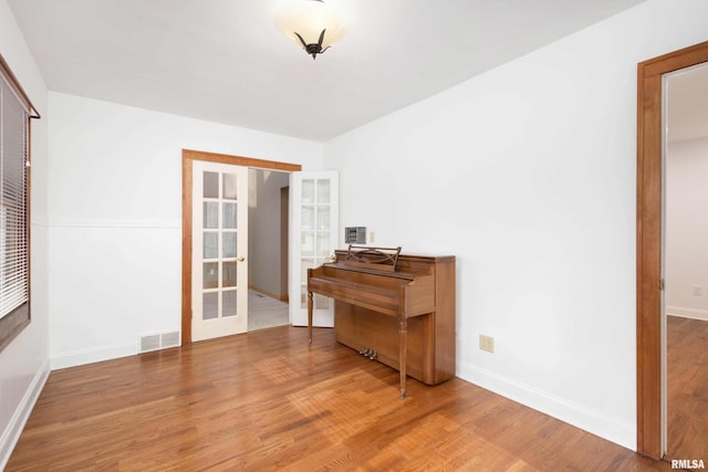 miscellaneous room with wood-type flooring and french doors