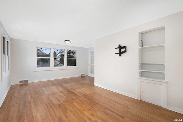 empty room with hardwood / wood-style flooring, a healthy amount of sunlight, and a textured ceiling