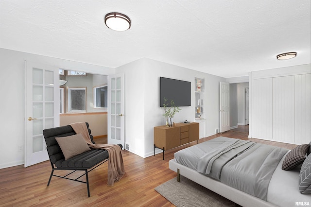 bedroom featuring hardwood / wood-style flooring, a textured ceiling, and french doors