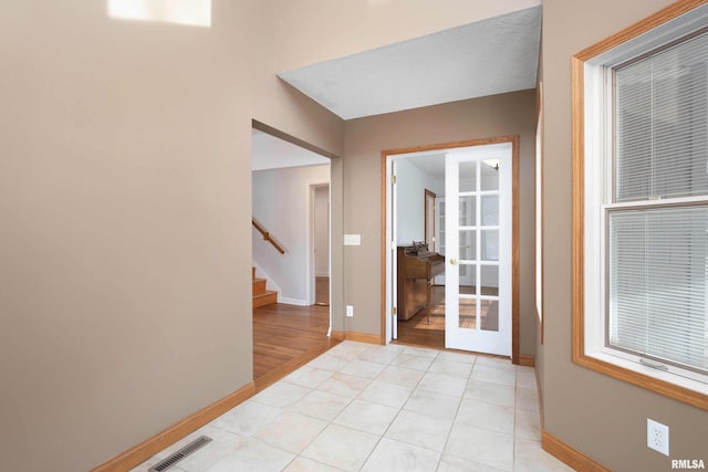 interior space featuring light tile patterned flooring and french doors