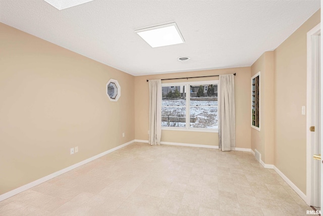 unfurnished room featuring a textured ceiling