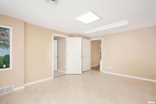 unfurnished room with a textured ceiling