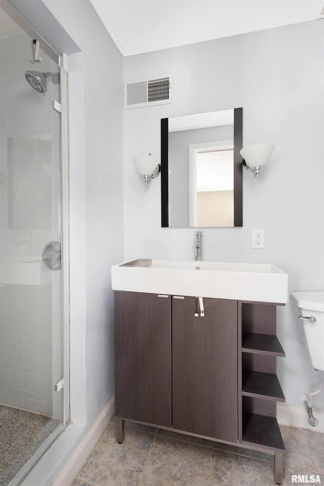 bathroom featuring vanity, a shower with door, and toilet