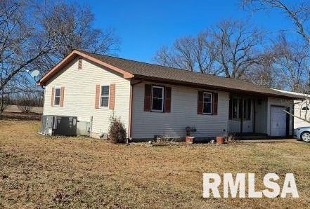 view of front of property with a garage, central AC unit, and a front yard