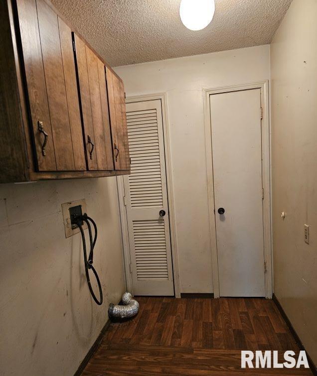 clothes washing area featuring cabinets, hookup for a washing machine, and a textured ceiling