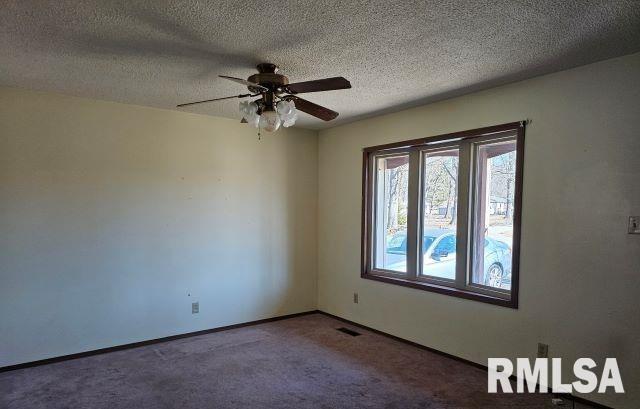 unfurnished room with ceiling fan, carpet, and a textured ceiling