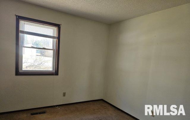 unfurnished room with a textured ceiling