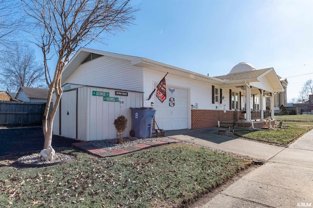 ranch-style house featuring a garage, a front lawn, and covered porch