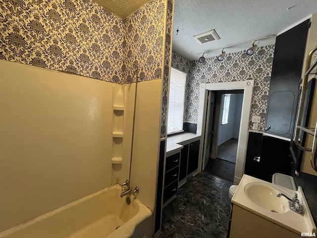 full bathroom featuring toilet, vanity, bathtub / shower combination, and a textured ceiling